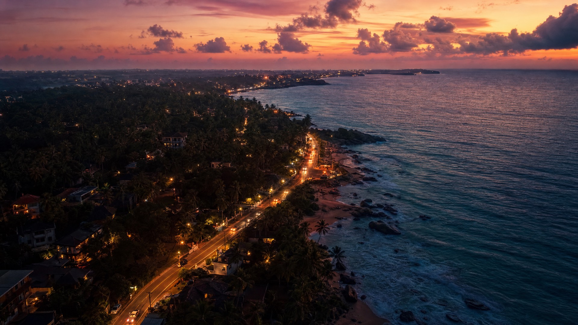 Aerial view of the south-coast road winding along the shoreline at dusk.